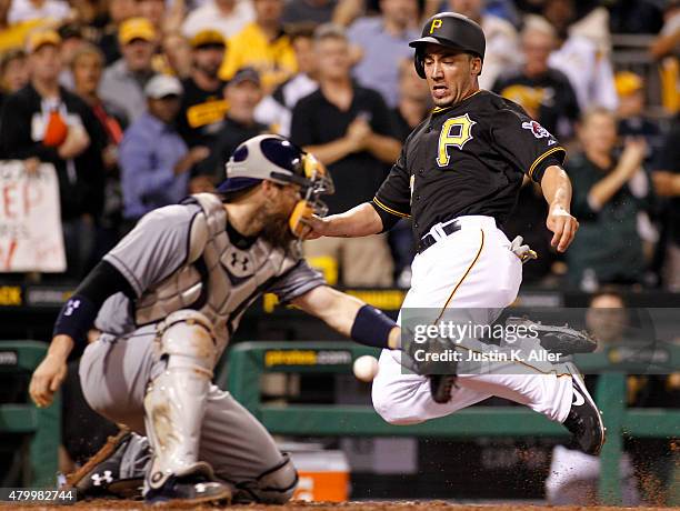 Travis Ishikawa of the Pittsburgh Pirates slides in safe against catcher Derek Norris of the San Diego Padres on a RBI single in the eighth inning...