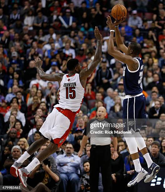 Raptors big man Amir Johnson goes flying out to try to stop the shot of Thunder's big man, Kevin Durant. Toronto Raptors vs Oklahoma Thunder during 1...