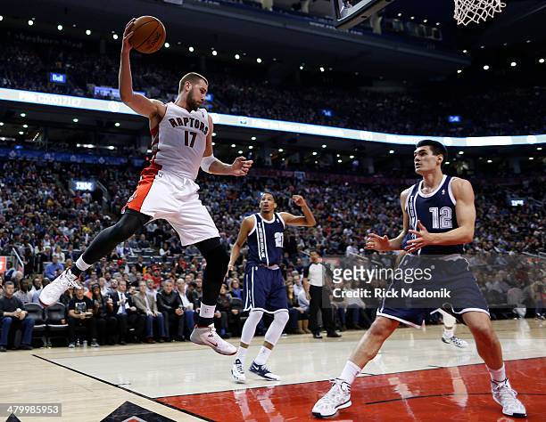Raptor Jonas Valanciunas looks to throw the ball off of Thunder's Steven Adams as he saves the ball from out of bounds. Toronto Raptors vs Oklahoma...