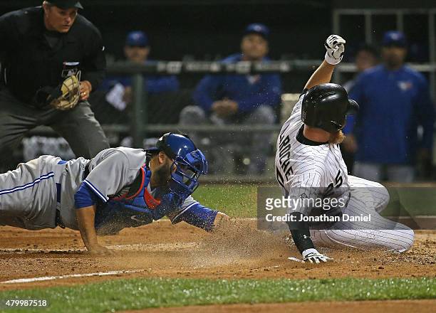 Adam LaRoche of the Chicago White Sox scores a run in the 6th inning as Dioner Navarro of the Toronto Blue Jays attempts the tag at U.S. Cellular...