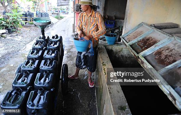 Man fills a jerry can with clean water on World Water Day March 22, 2014 in Surabaya, Indonesia. World Water Day recognizes the global need for water...