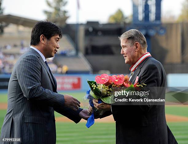 Former Los Angeles Dodgers pitcher Hideo Nomo, presents flowers to former Dodgers President Peter O'Malley after he received The Order of the Rising...