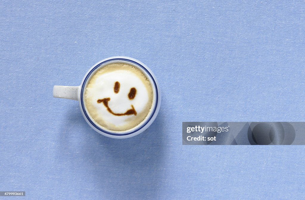 Latte with smiling face shaped foam,aerial view