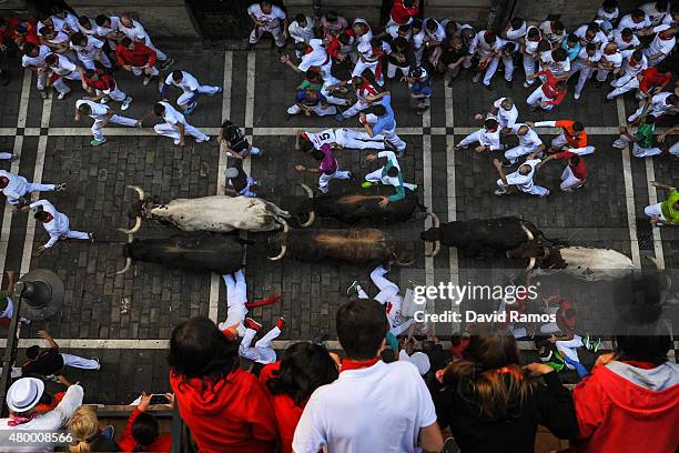 Revellers run with the Victoriano del Rio Cortes' fighting bulls along Estafeta street during the fourth day of the San Fermin Running of the Bulls...