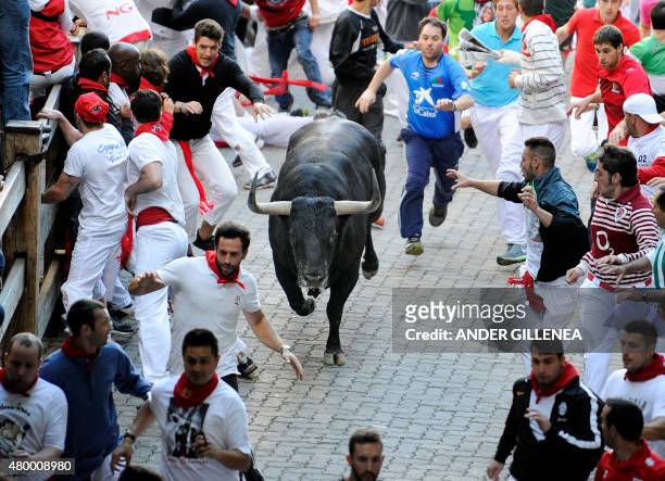 Participants run in front of Victoriano del Rio Cortes' bulls during the third "encierro" of the San Fermin Festival in Pamplona, northern Spain, on...