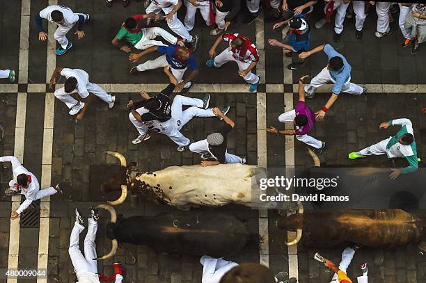 Revellers run with the Victoriano del Rio Cortes' fighting bulls along Estafeta street during the fourth day of the San Fermin Running of the Bulls...