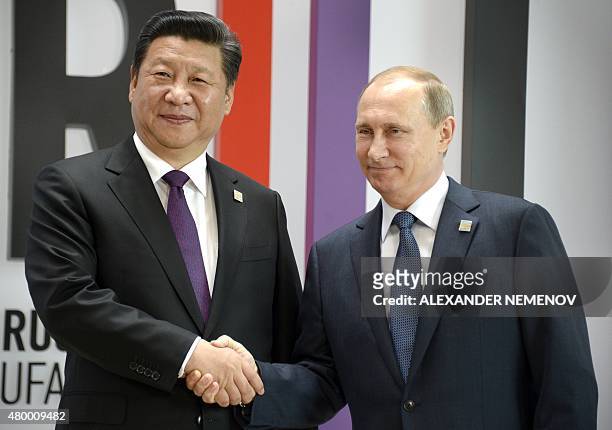 Russia's President Vladimir Putin greets China's President Xi Jinping during a welcome ceremony in Ufa on July 9, 2015 at the start of the 7th BRICS...