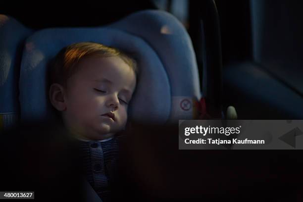 little baby boy soundly sleeping in car seat - sleeping in car fotografías e imágenes de stock