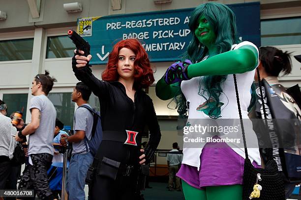 Attendees dressed as characters from Marvel Comics stand outside the San Diego Convention Center during the Comic-Con International convention...