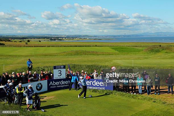 Jamie Donaldson of Wales hits his tee shot on the third hole as a gallery of patrons look on during the first round of the Aberdeen Asset Management...