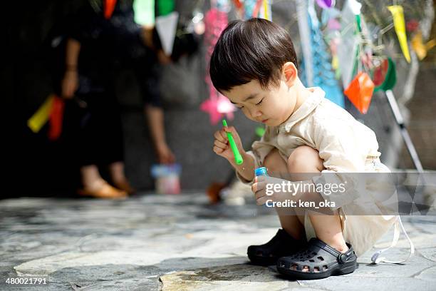 a kid blows soap bubbles - tanabata festival 個照片及圖片檔