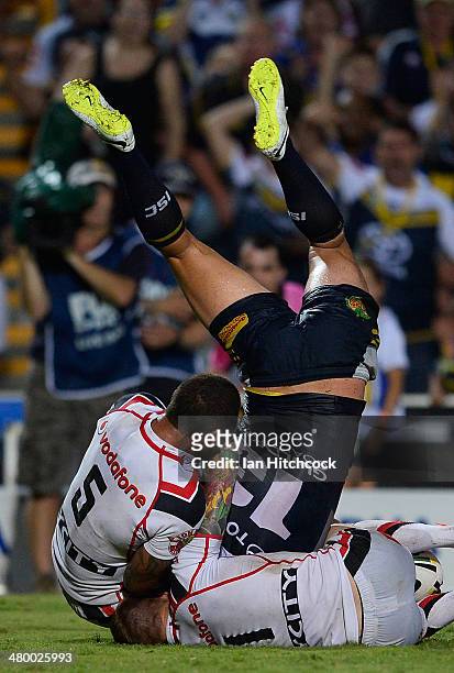 Tariq Sims of the Cowboys is held up in goal by Manu Vatuvei and Sam Tomkins of the Warriors during the round three NRL match between the North...
