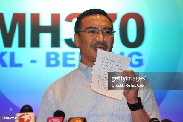 Malaysia's Minister of Defence and acting Minister of Transport Hishammuddin Hussein shows a note of latest information from Chinese officials during...