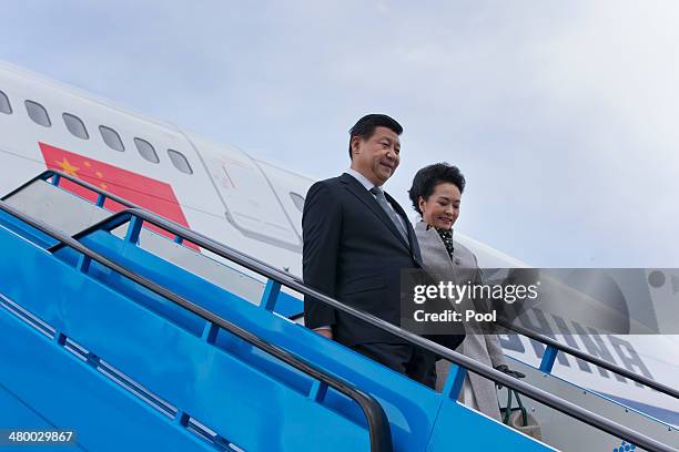 China's President Xi Jinping and his wife Peng Liyuan walk down the stairs from their aircraft prior to being greeted by King Willem-Alexander of the...