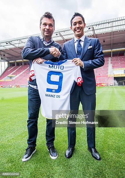 New signing player Yoshinori Muto of 1. FSV Mainz 05 shakes hands with manager Christian Heidel during his unveiling at Coface Arena during on July...