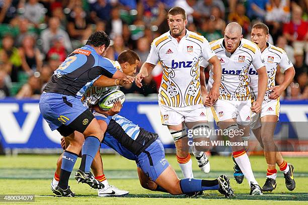 Tim Nanai-Williams of the Chiefs is tackled by Kieran Longbottom and Pek Cowan of the Force during the round six Super Rugby match between the Force...