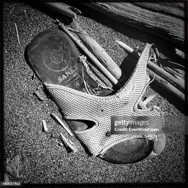 Collection of shoes as flotsam and jetsam on the beach on June 28, 2015 in Kattavia, Rhodes, Dodecanes, Greece.