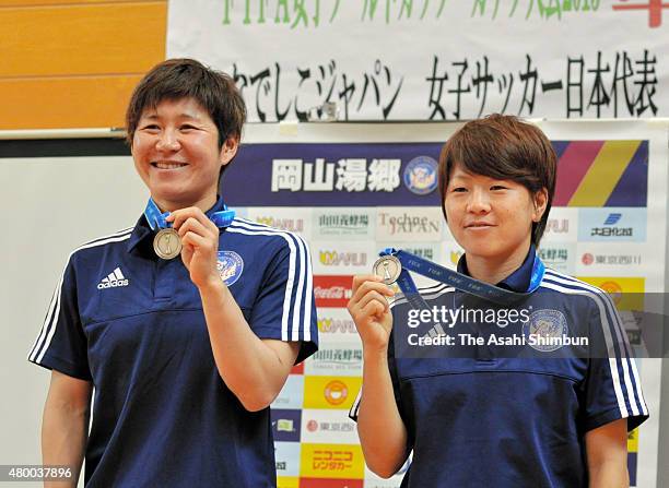 Miho Fukumoto and Aya Miyama show their World Cup medals during the Okayama Yunogo Bell press conference on July 9, 2015 in Mimasaka, Okayama, Japan.