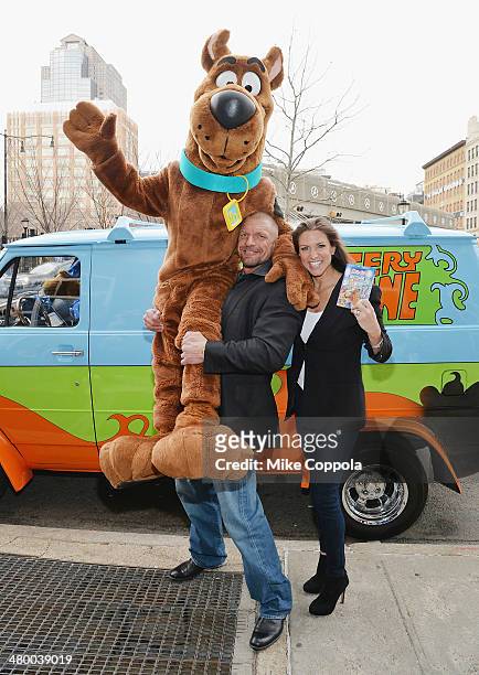 Wrestler Triple H and Stephanie McMahon lift Scooby Doo in the air during the "Scooby Doo! WrestleMania Mystery" New York Premiere at Tribeca Cinemas...