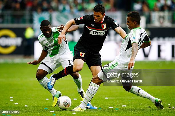 Raul Bobadilla of Augsburg and Junior Malanda of Wolfsburg compete for the ball during the Bundesliga match between and VfL Wolfsburg and FC Augsburg...