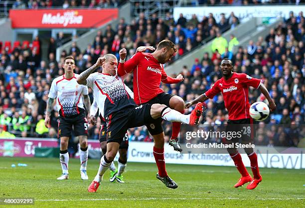 Martin Skrtel of Liverpool scores his team's second goal despite the challenge from during the Barclays Premier League match between Cardiff City and...