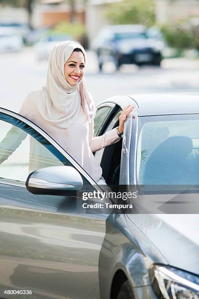 middle easter woman entering a luxury car in dubai - dubai woman driving car stockfoto's en -beelden