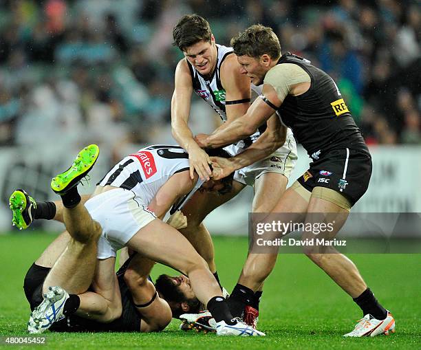 Taylor Adams of the Magpies and Justin Westhoff sf the Power scuffle whilst team mates try to seperate them during the round 15 AFL match between...