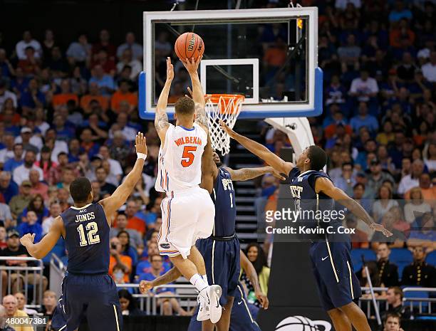 Scottie Wilbekin of the Florida Gators makes a three-pointer as time expires in the first half over Jamel Artis of the Pittsburgh Panthers during the...