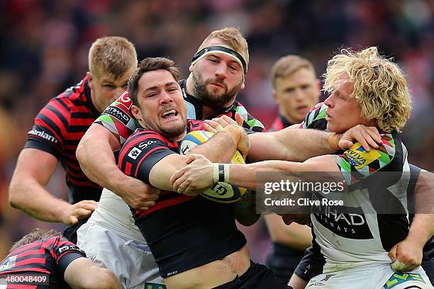 Brad Barritt of Saracens is trackled by Joe Marler and Matt Hopper of Harlequins during the Aviva Premiership match between Saracens and Harlequins...