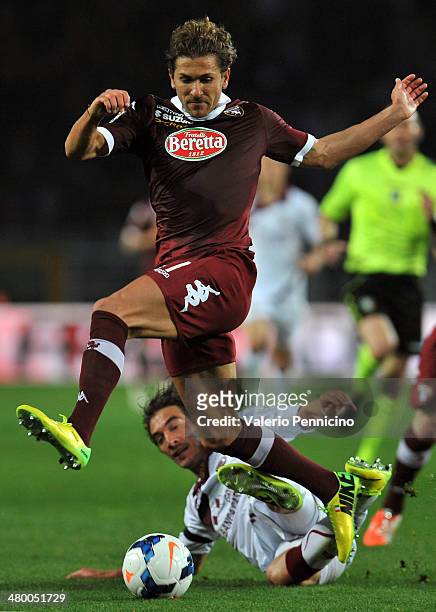 Alessio Cerci of Torino FC is tackled by Paolo Castellini of AS Livorno Calcio during the Serie A match between Torino FC and AS Livorno Calcio at...