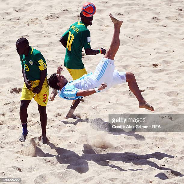 Miguel de Ezeyza of Argentina does an overhead kick against Ngalla Sylla and Ibrahima Balde of Senegal during the FIFA Beach Soccer World Cup...