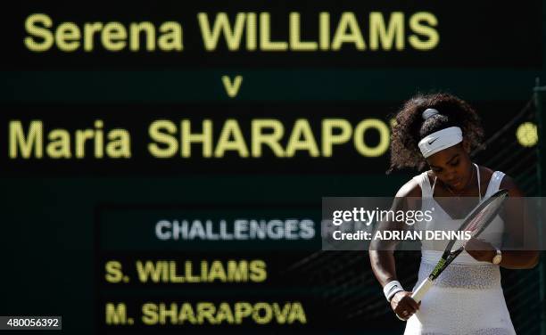 Player Serena Williams checks her racquet between points against Russia's Maria Sharapova in their women's semi-final match on day ten of the 2015...