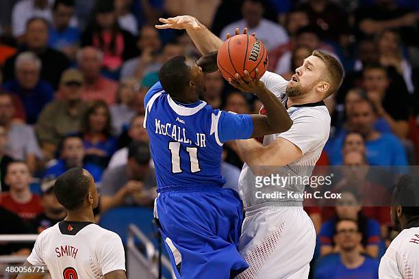 Mike McCall Jr. #11 of the Saint Louis Billikens goes up for a shot against Stephan Van Treese of the Louisville Cardinals in the first half during...