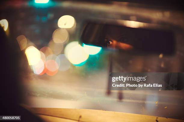 woman eyes reflected in rear mirror of car - rear view mirror stock pictures, royalty-free photos & images