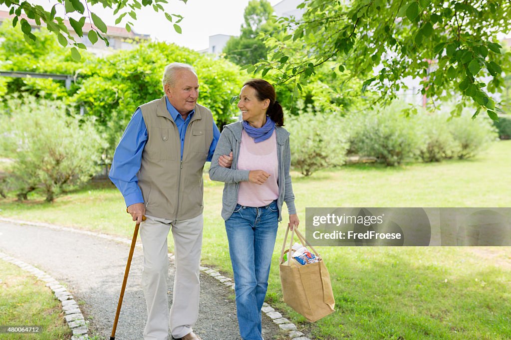 Caregiver – woman helping senior man with shopping