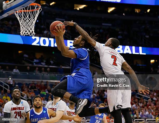 Jordair Jett of the Saint Louis Billikens goes up for a shot in front of Russ Smith of the Louisville Cardinals in the second half during the third...