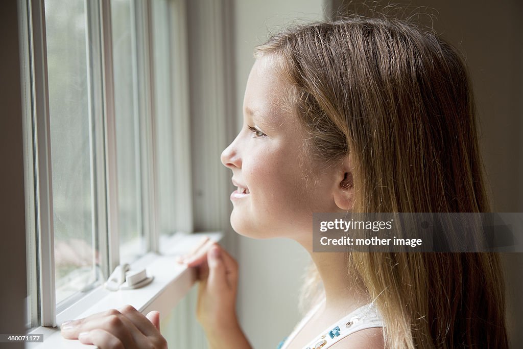 Young caucasian girl looking out window