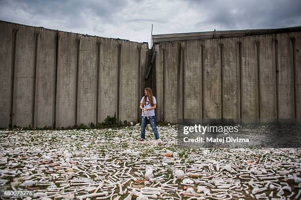 Woman holds ceramic bones as part of 'The One Million Bones' project in front of the hall at the Potocari cemetery and memorial near Srebrenica on...