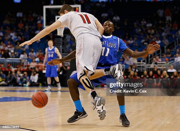 Luke Hancock of the Louisville Cardinals is called for traveling against Mike McCall Jr. #11 of the Saint Louis Billikens in the second half during...