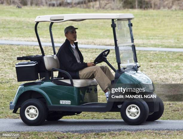 President Barack Obama drives a golf cart at the Andrews Air Force Base golf course in Maryland on March 22, 2014. The White House has billed...