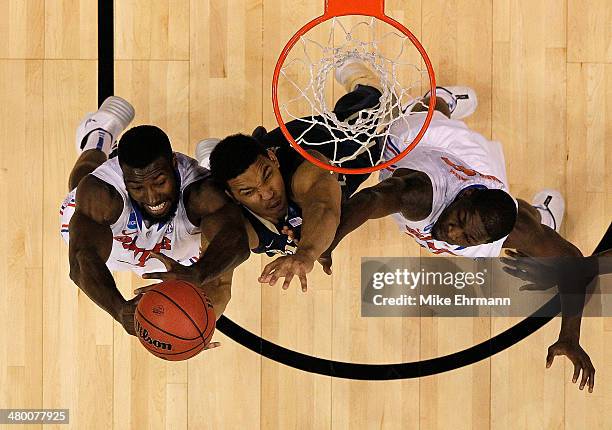 Derrick Randall of the Pittsburgh Panthers attacks the basket defended by Patric Young and Dorian Finney-Smith of the Florida Gators during the third...