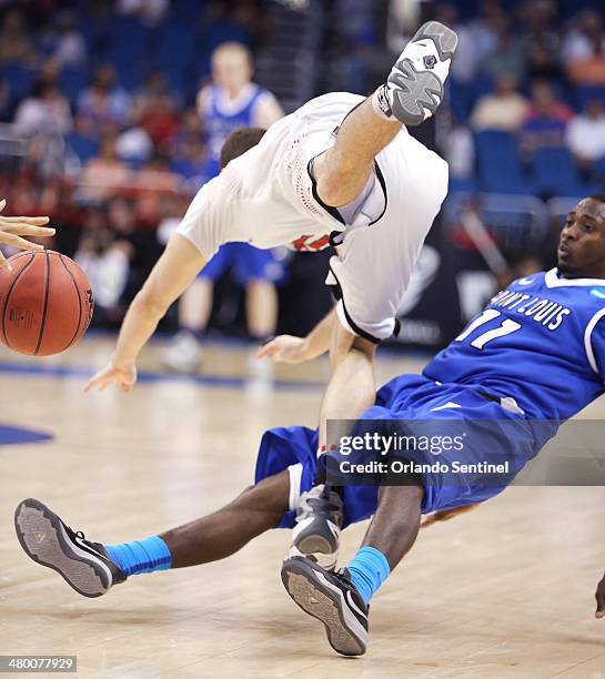 Louisville's Luke Hancock, top, collides with Saint Louis' Mike McCall Jr. In the third round of the NCAA Tournament at the Amway Center in Orlando,...