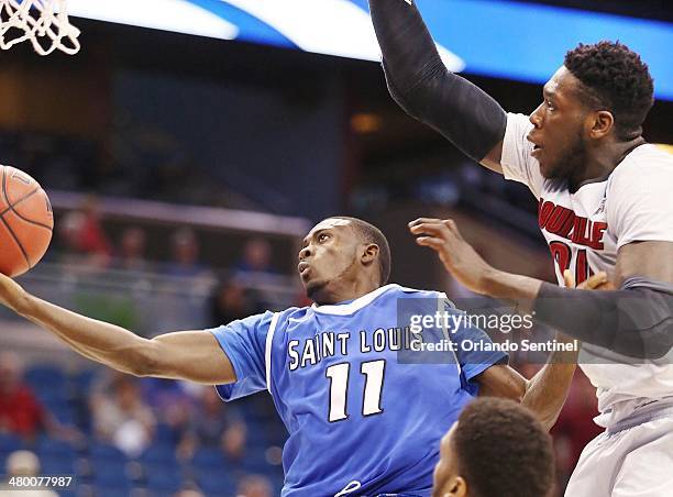 Saint Louis' Mike McCall Jr. Scores under Louisville's Montrezl Harrell in the third round of the NCAA Tournament at the Amway Center in Orlando,...