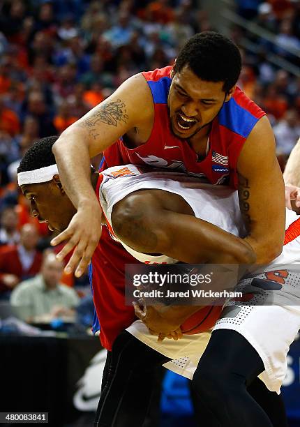 Fair of the Syracuse Orange holds the ball as Jalen Robinson of the Dayton Flyers defends during the third round of the 2014 NCAA Men's Basketball...