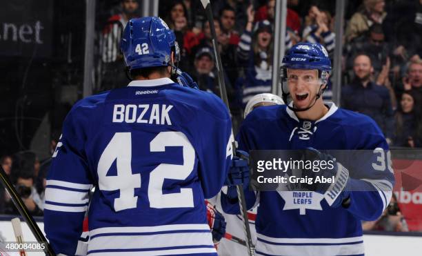 Tyler Bozak and Carl Gunnarsson of the Toronto Maple Leafs celebrate a first period goal during NHL game action against the Montreal Canadiens March...