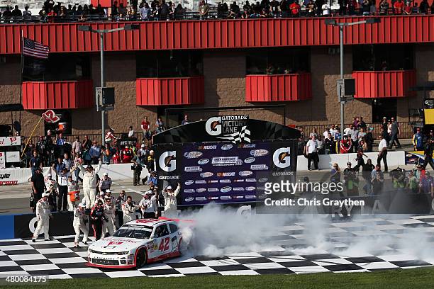 Kyle Larson, driver of the Cartwheel Chevrolet, celebrates with a burnout after winning the NASCAR Nationwide Series TREATMYCLOT.COM 300 at Auto Club...