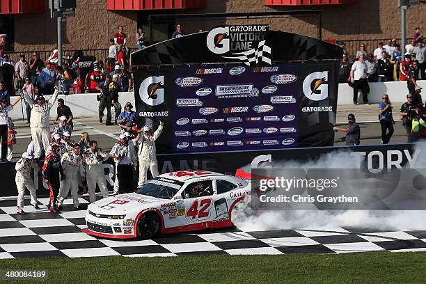 Kyle Larson, driver of the Cartwheel Chevrolet, celebrates with a burnout after winning the NASCAR Nationwide Series TREATMYCLOT.COM 300 at Auto Club...