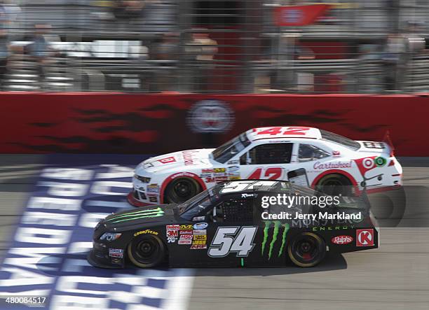 Kyle Busch, driver of the Monster Energy Toyota, and Kyle Larson, driver of the Cartwheel Chevrolet, race during the NASCAR Nationwide Series...