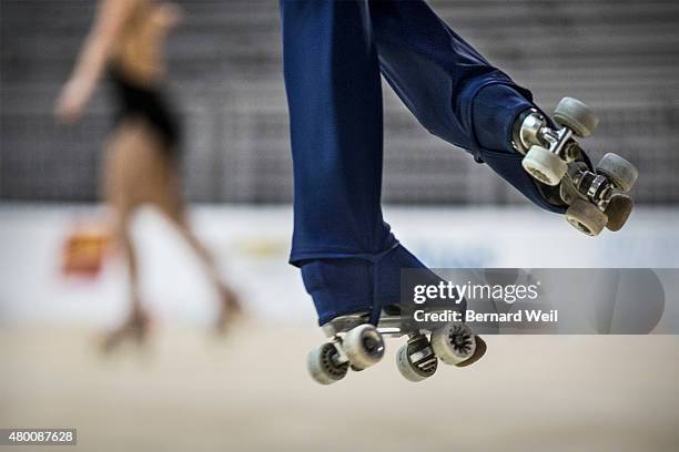Columbian Roller Figure Skater Diago Duque gets airborne as he practices his routine during a training session, as Canadian Kailah Macri skates by,...