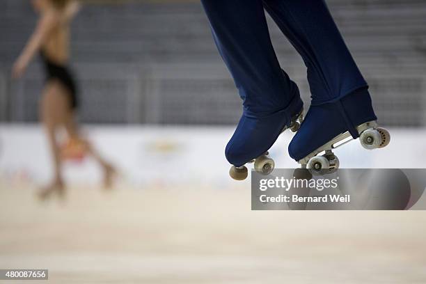 Columbian Roller Figure Skater Diago Duque gets airborne as he practices his routine during a training session, as Canadian Kailah Macri skates by,...